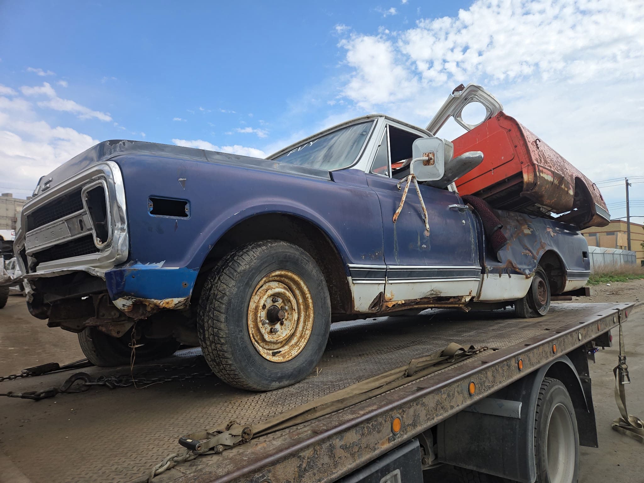 Old pickup truck secured on a flatbed for free towing